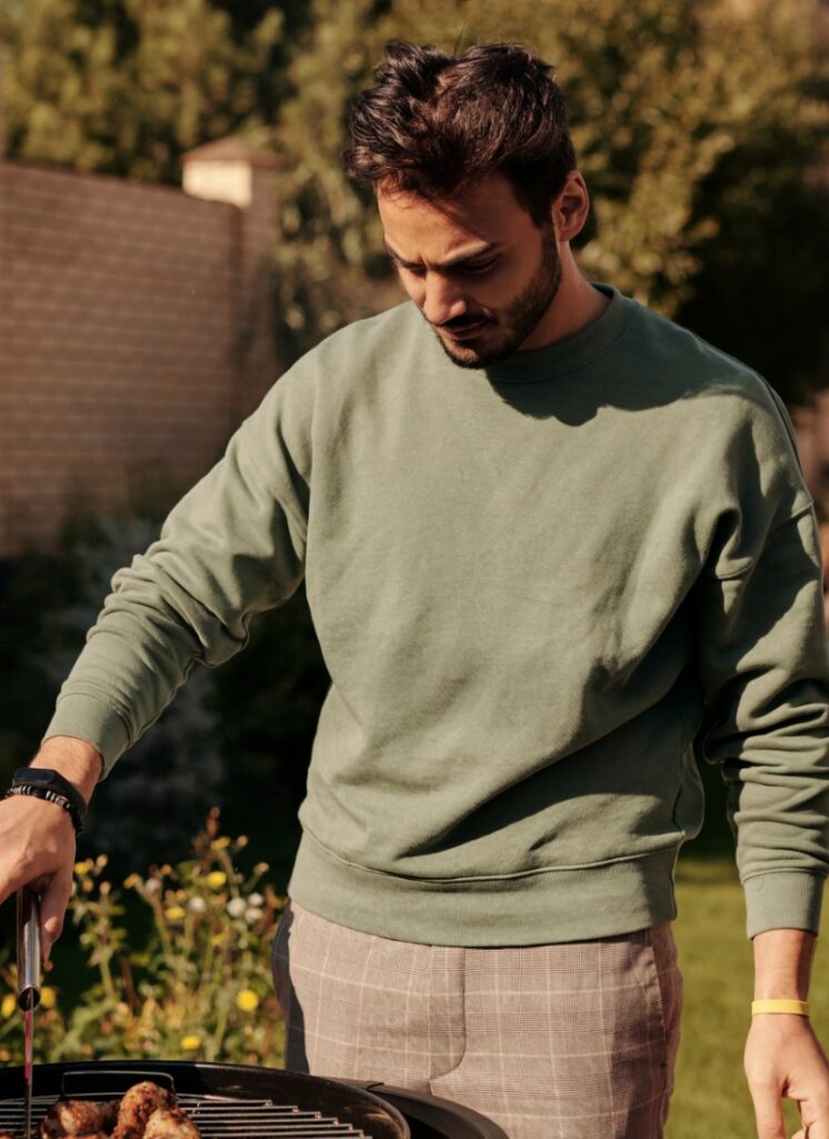 HOMME EN TRAIN DE CUISINER UN BARBECUE